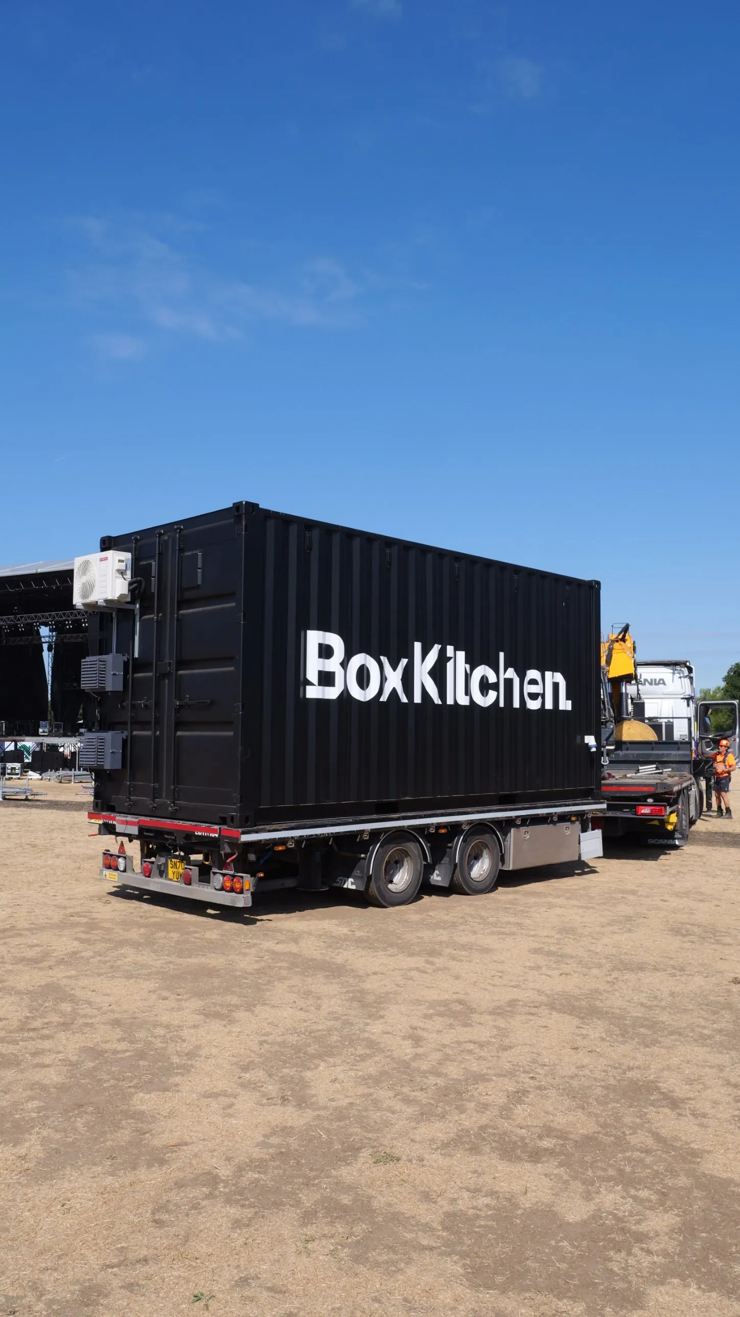 Black BoxKitchen shipping container kitchen on the back of a flatbed lorry, arriving on a festival site