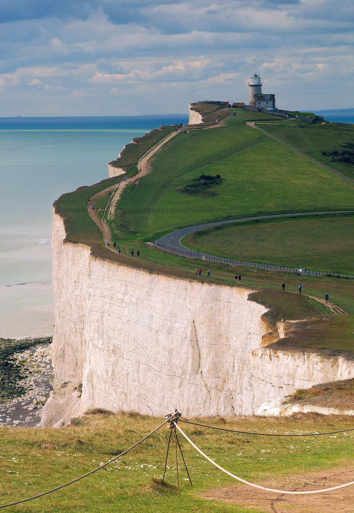 The white chalk cliffs of the Seven Sisters with Belle Tout lighthouse on the clifftop above a turquoise sea